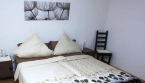 un lit avec des draps blancs et des oreillers dans une chambre dans l'établissement Seepark Falk Wohnung Nr -2-, à Fribourg-en-Brisgau