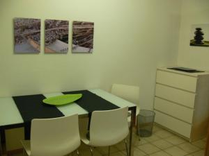 une salle à manger avec une table et des chaises blanches dans l'établissement Seepark Falk Wohnung Nr -2-, à Fribourg-en-Brisgau 2 autres photos