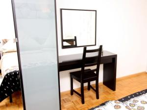 - un bureau noir avec une chaise et un miroir dans l'établissement Seepark Falk Wohnung Nr -2-, à Fribourg-en-Brisgau