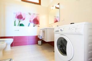a white washing machine in a bathroom with pink walls at Villa con piscina in parco privato in Agnone
