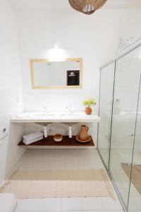 un bagno bianco con lavandino e specchio di Raízes - House on the Aracaju Waterfront ad Aracaju Altre 26 foto