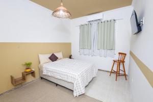 una piccola camera da letto con un letto e una finestra di Raízes - House on the Aracaju Waterfront ad Aracaju