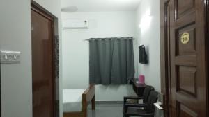 a room with a door and a green shower curtain at JK Residency in Virudunagar