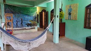 una hamaca en una habitación con una pintura en la pared en Artetude Hostel Cultural, en Barra de Guaratiba