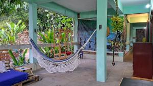 un porche con hamaca en una habitación con plantas en Artetude Hostel Cultural, en Barra de Guaratiba