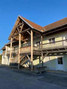 a building with a wooden deck on the side of it at Ferienwohnung Maier in Fürstenfeld