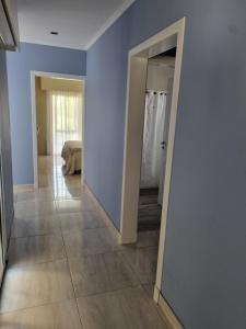 a hallway with blue walls and a mirror at Céntrico con cochera in Coronel Suárez