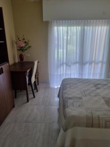 een slaapkamer met een bed, een bureau en een raam bij Céntrico espacio en CS in Coronel Suárez