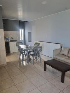 een woonkamer met een tafel, stoelen en een bank bij Céntrico espacio en CS in Coronel Suárez