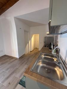 a kitchen with a sink and a wooden floor at Casa Ottema 3 in Nebida