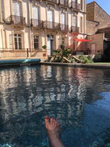 il piede di una persona nell'acqua di fronte a un edificio di La maison bachelet a Claira