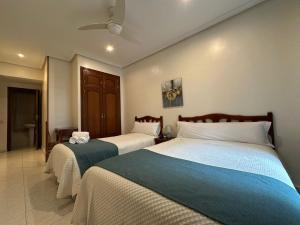 dwa łóżka w pokoju hotelowym z dwoma łóżkami w obiekcie Hostal Villamañez w Madrycie +9 zdjęć