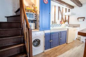 a kitchen with blue cabinets and a washing machine at La Petite Hermine in Amboise