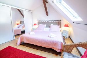 a bedroom with a large bed with a red rug at La Petite Hermine in Amboise