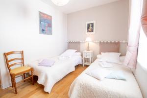 a room with two beds and a chair in it at La Petite Hermine in Amboise +2 photos