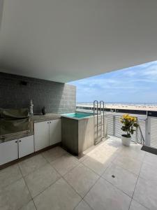 a kitchen with a swimming pool on a balcony at Comfortable duplex - Punta Hermosa in Punta Hermosa