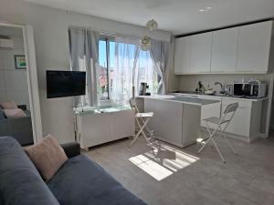 a living room with a couch and a kitchen with a window at Macé9 in Cannes