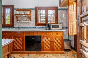 a kitchen with wooden cabinets and a microwave at Carmen de los Moriscos - Alhambra views in Granada +33 photos