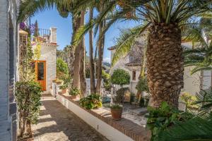 a courtyard with palm trees and a building at Carmen de los Moriscos - Alhambra views in Granada