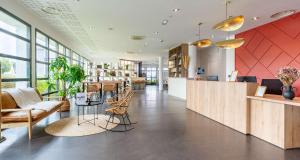 a lobby with chairs and tables in a building at Best Western Hôtel De La Cité & Spa in Guérande