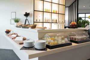 une boulangerie avec un buffet de nourriture sur un comptoir dans l'établissement Best Western Hôtel De La Cité & Spa, à Guérande