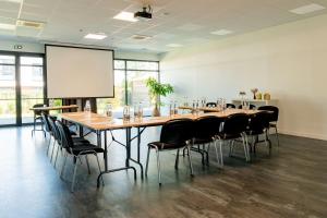 une grande salle de conférence avec une grande table et des chaises dans l'établissement Best Western Hôtel De La Cité & Spa, à Guérande 29 autres photos