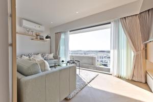 チェンマイにあるPenthouse Condo I Mountain Viewのソファと大きな窓のあるリビングルーム