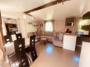 a living room with a couch and a table at Mobi Home Palmiers 2 in Valras-Plage