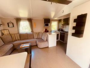 a living room with a couch and a kitchen at Mobi Home Palmiers 2 in Valras-Plage