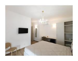 a bedroom with a white bed and a chandelier at La Principessa Nera B&B in Ostra