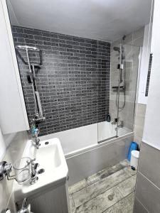 a bathroom with a sink and a shower and a tub at Crosland Cottage in Holmfirth