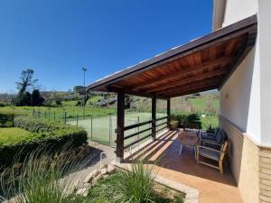 a patio with a wooden pergola and chairs at la valle country house in Vasto