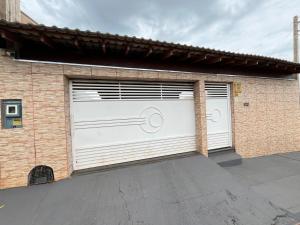 un garaje con una puerta blanca con una bicicleta. en Recanto Belmonte, en Olímpia
