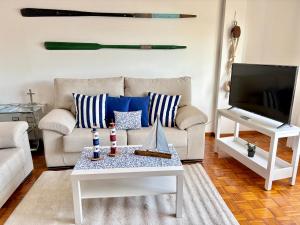 a living room with a couch and a tv at Apartamento con vistas al mar en Primera Línea. in Muros