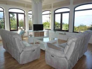 two chairs and a table in a living room with windows at Casa Paradiso in Porto Valtravaglia