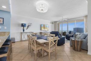 a dining room and living room with a table and chairs at Emerald Key 603- Wrap Around Balcony Top Floor in Orange Beach +30 photos