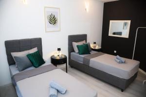 two beds in a room with green and white at Mostar Comfort Suites in Mostar