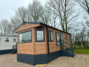 a tiny house sitting in a parking lot at Westfield Lodge Retreat-Sleeps 6-Pet Friendly in Carnforth