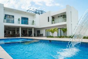 a house with a swimming pool and a fountain at Cabaña CasaBlanca in Santa Marta
