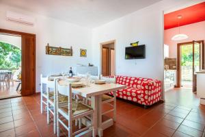 Una cocina y una sala de estar con una mesa y un sofá. en Villa Acquamarina - 300 meters from the sea, en Scopello