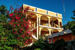 巴利亚多利德Hotel Boutique Kiin Wayeb的一栋前面有粉色花朵的建筑