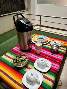 un tavolo con caffettiera e piatti di cibo di HAYLLI QOSQO Hotel Inn a Cuzco