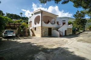 una casa con un coche aparcado delante en Villa Acquamarina - 300 meters from the sea, en Scopello