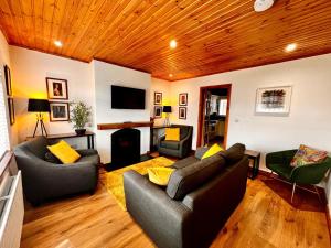 a living room with two couches and a television at Comfy Cottage in Ballymena