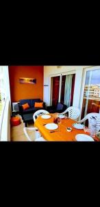 un soggiorno con un tavolo e un divano di Praia da Rocha Flamingo Residence Summer a Portimão