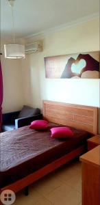 una camera con un letto con due cuscini rosa di Praia da Rocha Flamingo Residence Summer a Portimão