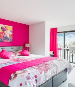 a bedroom with pink walls and a large bed at Absolu chic naturiste in Cap d'Agde