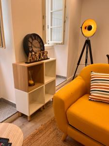 a living room with a yellow couch and a shelf at Valma GuestHouse in Viana do Castelo