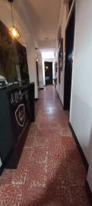 a hallway with a red tile floor in a building at Hotel El Barcino in Neiva