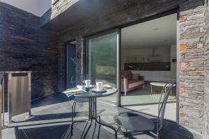 a patio with a table and chairs and a living room at Apartamentos PUERTO DE VIAVELEZ in Viavélez
